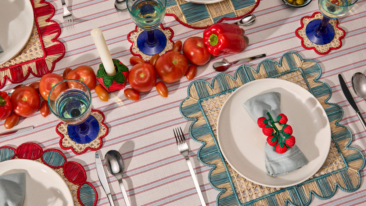Long table with handwoven placemats and a row of tomatoes down the center, working like a runner