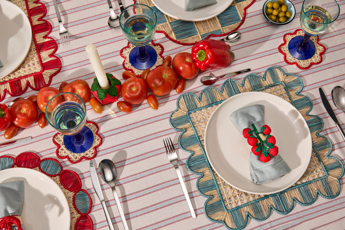 Long table with handwoven placemats and a row of tomatoes down the center, working like a runner